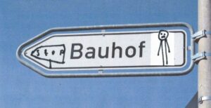 Bauhof-Wegweiser-Schild, in den ein trauriges Nixklusionsmännchen und ein Stop-Schild hineingemalt sind. (Collage).